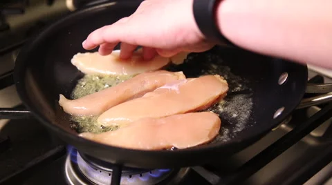 Chicken being placed on frying pan Stock Footage 61351185