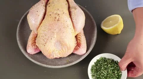 A chicken being sprinkled with herbs Stock Footage 24671260