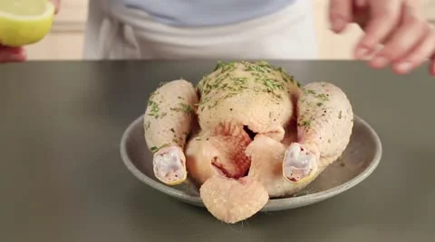 A chicken being stuffed with lemon and rosemary Stock Footage 24671264