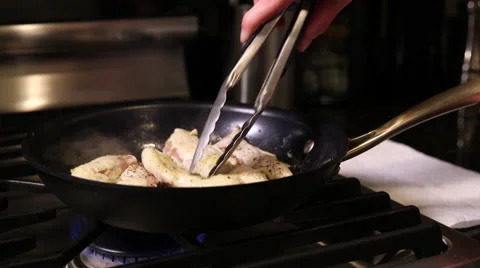 Chicken being turned over on frying pan Stock Footage 61350210