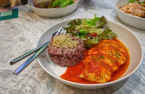 Chicken breast cooked with curry paste with brown rice and vegetables Stock Photos