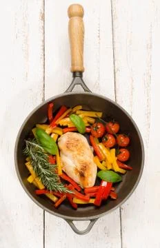 Chicken breast filet in a cast iron pan with vegetables Stock Photos