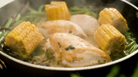 Chicken breasts and corn cooking in a frying pan Stock-Footage 333831344