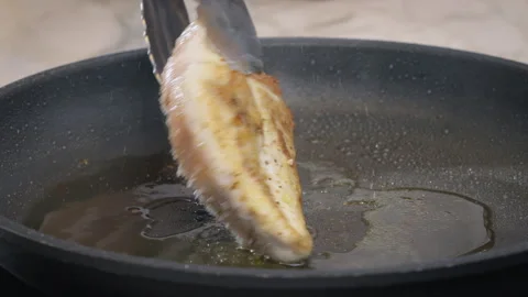 Chicken breasts are flipped on a pan, close - up. Slow motion video 100fps. Stock Footage 272817052