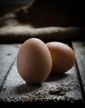 Chicken brown egg on a vintage rustic wooden board. Stock Photos