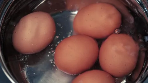 Chicken brown eggs are cooked in a metal saucepan in boiling water. closeup. Stock Footage 255384061