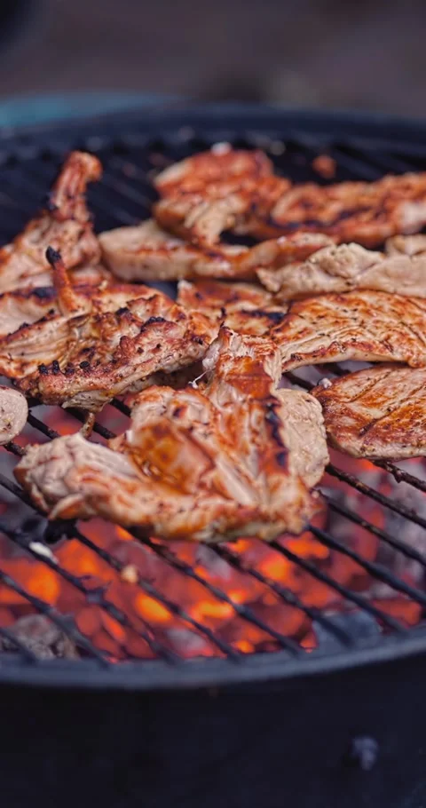 Chicken Browning Slowly Over Live Coals With Small Flame Bursts Stock Footage 333012526