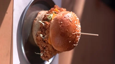 A chicken burger appears in front of the window on a sunny day Video stock 196143199