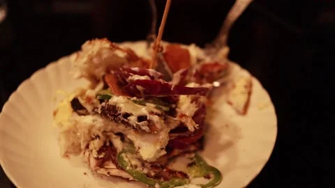 A chicken burger on a plate held by tooth prick cut by fork. Stock Footage 153511454