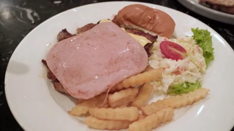 Chicken chop topped with a slice of ham and melted cheese Stock Footage 343552318