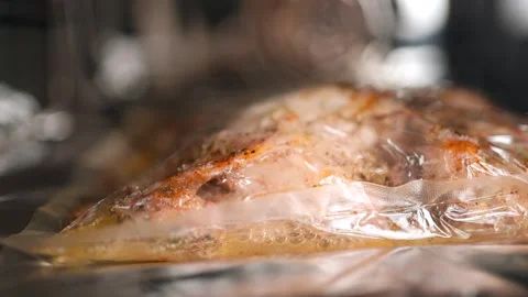 The chicken is cooked in the oven in a baking bag. Macro photography of bubbling Stock Footage 250320393