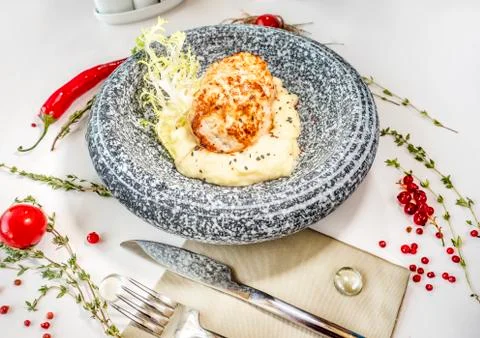Chicken cutlets with mashed potatoes in a marble plate on a table in a restau Stock Photos