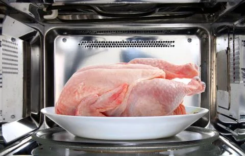 Chicken defrosting using microwave oven Stock Photos