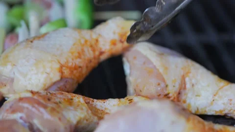 Chicken drumstick closeup placed on grill slow motion Stock Footage 197343113