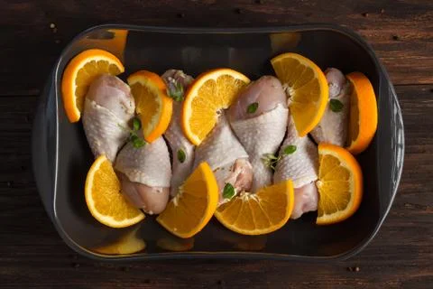 Chicken drumstick with oranges in a baking dish. Stock Photos