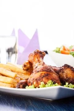 Chicken drumsticks with chips. selective focus Stock Photos