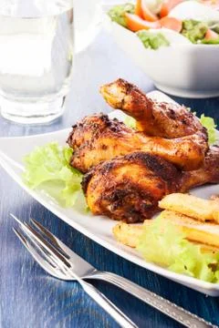 Chicken drumsticks with chips. selective focus Stock Photos