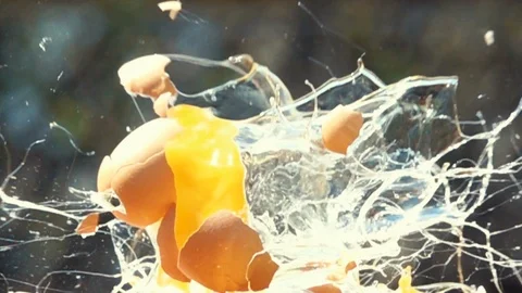 Chicken egg breaks from a bullet shot Stock Footage 121147430