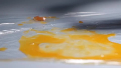 A chicken egg breaks from falling onto a table. Stock Footage 157327700
