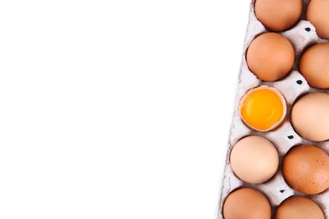 Chicken egg is half broken among other eggs. Chicken eggs in containers on gr Foto stock