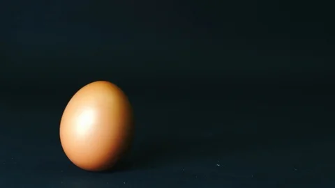 Chicken egg is spinning on a black background and out of the frame. Slow motion Stock Footage 111413416