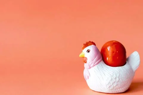 Chicken egg stand with orange egg on an orange background. Stock Photos