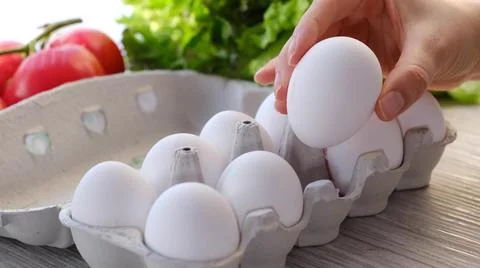 Chicken egg on the table. Easter eggs background. human hand takes one from eggs Stock Photos