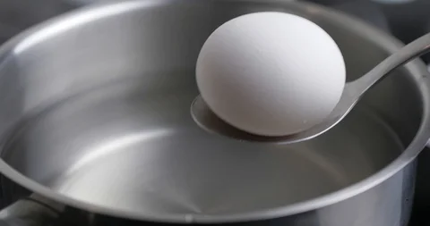 Chicken Egg On A Tablespoon Is Placed In Pan With Water To Boil The Egg Stock Footage 127755591