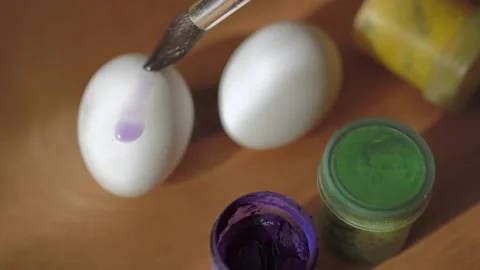 Chicken eggs and paints with a brush on a wooden surface. Easter. children'.. Stock Footage 237932064