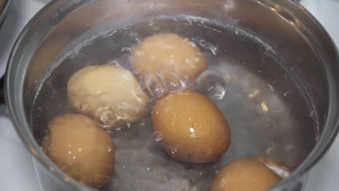 Chicken eggs are boiled in a saucepan in boiling water Stock Footage 110477989