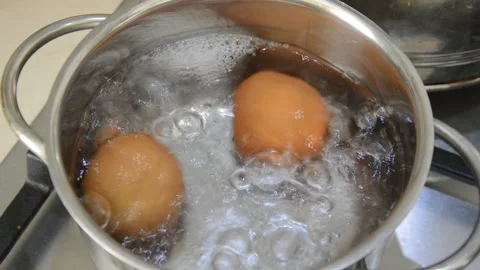 Chicken eggs are boiled in water in a saucepan on a gas stove. healthy breakfast Stock Footage 274268912