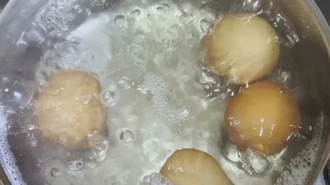 Chicken eggs are cooked in boiling water in a saucepan. Stock Footage 208930338