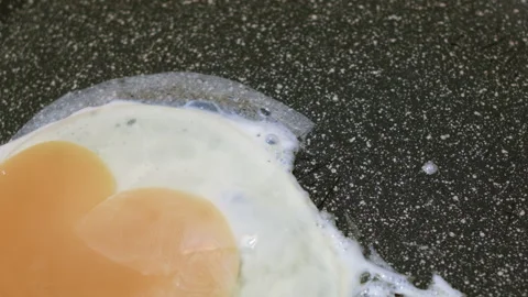 Chicken eggs are fried in a hot frying pan close-up. 스톡 동영상 135436623