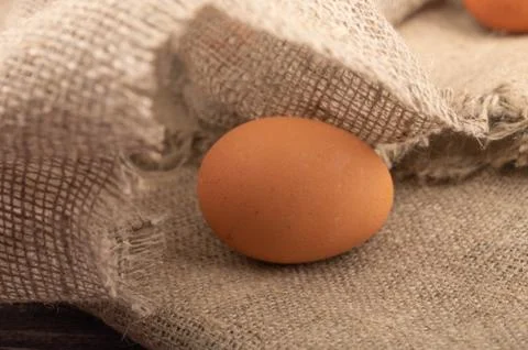Chicken eggs on a background of rough homespun fabric. Close up. Stock Photos