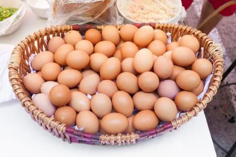 Chicken eggs in a basket isolate on white background Stock Photos