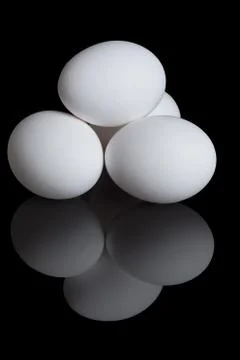 Chicken eggs on a black background Stock Photos