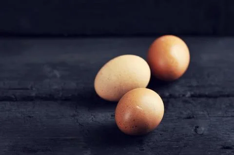 Chicken eggs on a black background Stock Photos