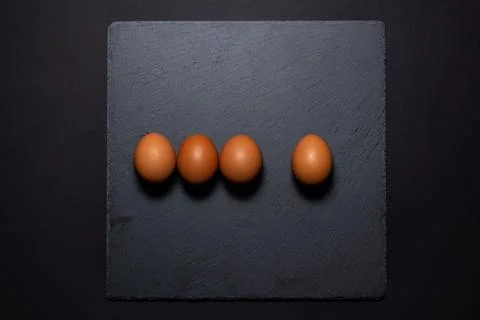 Chicken eggs on a black surface. Stock Photos