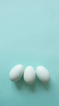 Chicken eggs on blue background bed monochrome shades, place for text Stock Photos