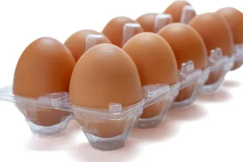 Chicken eggs in a clear plastic box on white background. Stock-Fotos