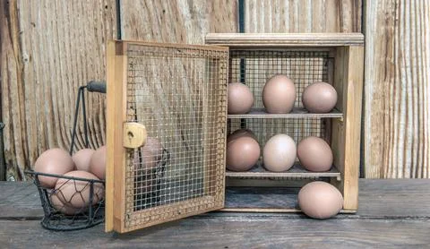 Chicken eggs  in a decorative box on a table  and a little metal basket in .. Stock Photos