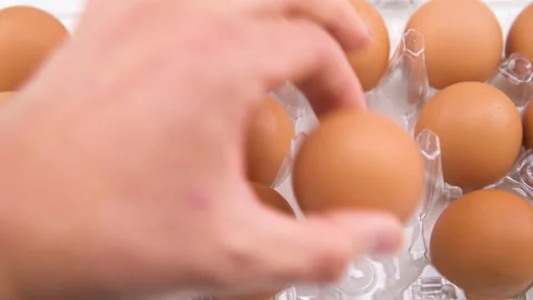 Chicken eggs dozen in plastic container, hand taking one egg macro closeup Stock Footage 227163996