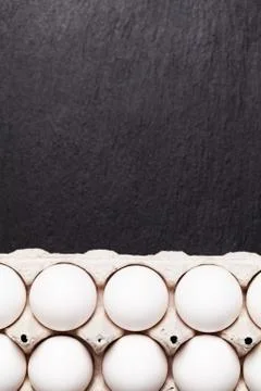 Chicken eggs in a package on a black table Stock Photos