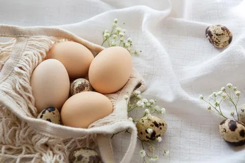 Chicken eggs in a string bag on white background, selective focus. Happy easter Stock Photos