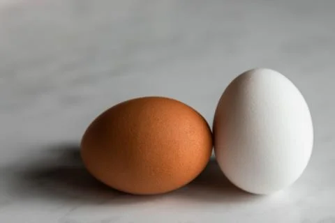 Chicken eggs. on the table. white egg. brown egg. white black background. 스톡 사진