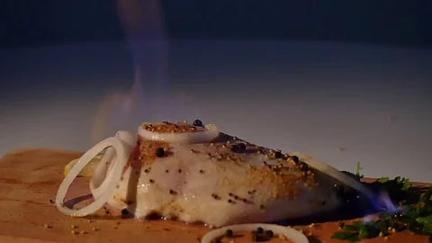 Chicken fillet in the fire on the wooden board. Barbecue meat. Dark background Stock Footage