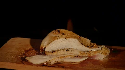 Chicken fillet in the fire on the wooden board. Barbecue meat. Dark background Stock Footage