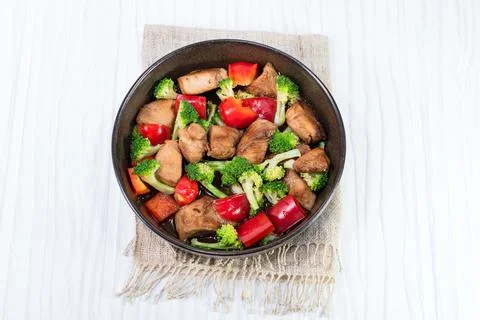 Chicken fried and vegetable broccoli pepper in bowl on white table. Stock Photos