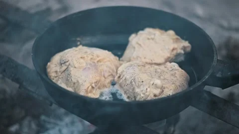 Chicken frying in a pan on campfire Stock Footage 303824281
