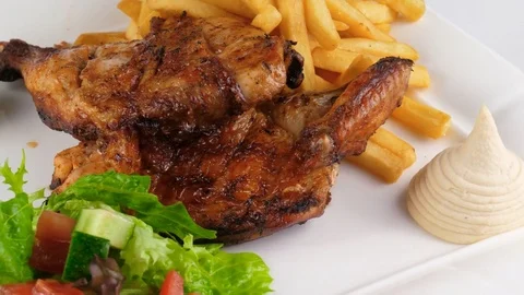 Chicken grill or barbecue with french fries and vegetables Stock Footage